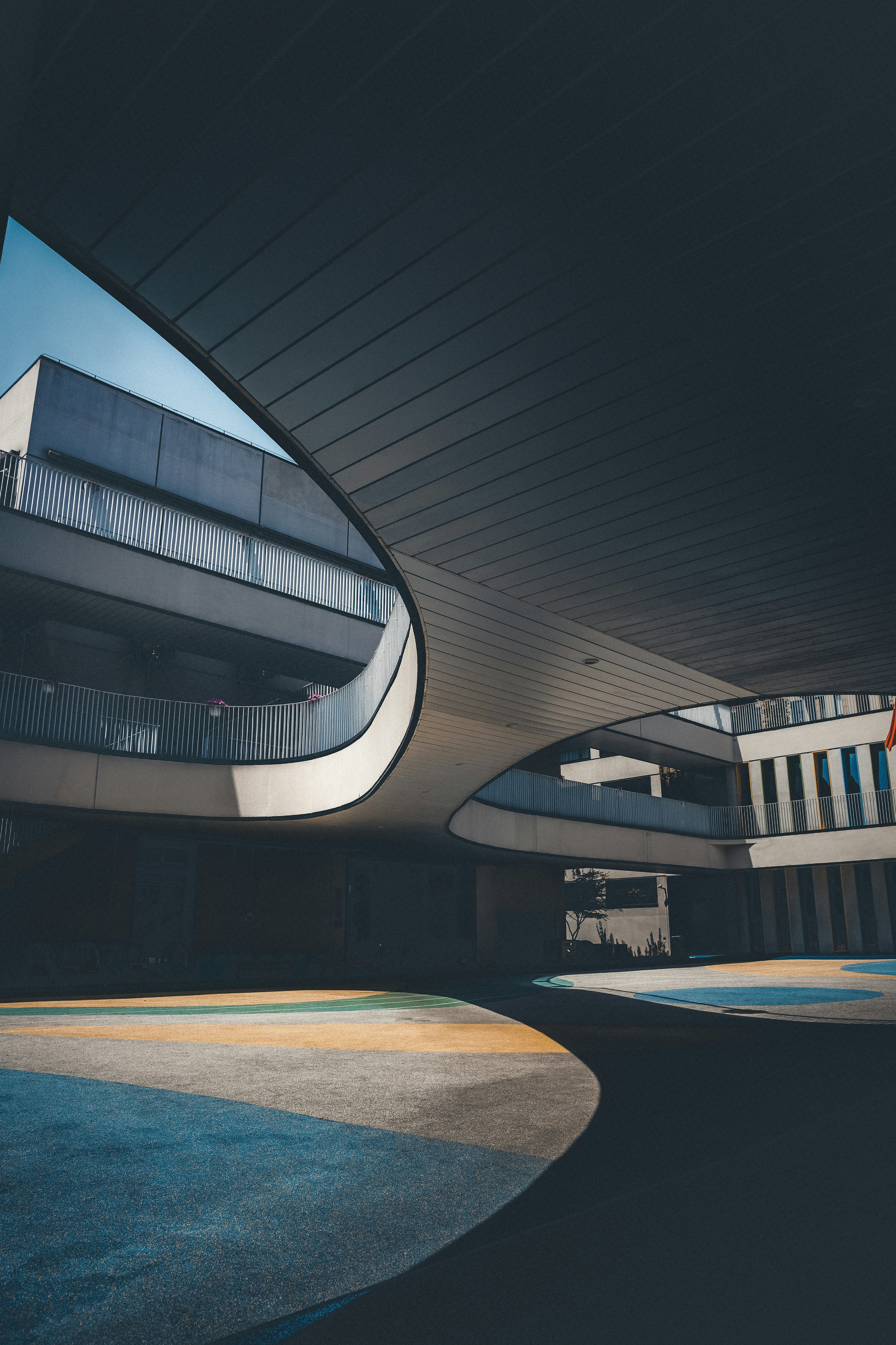 A building with a curved roof and a circular walkway photo – Free Floor ...
