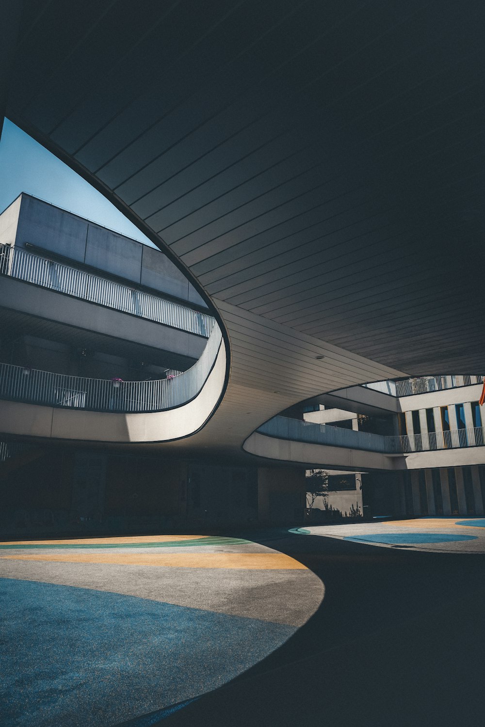 a building with a curved roof and a circular walkway