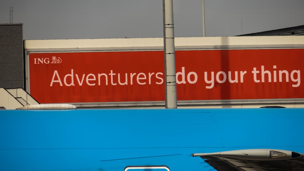 a red sign that says adventures do your thing