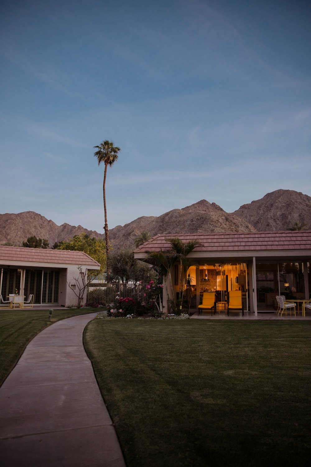 a house with a palm tree and mountains in the background