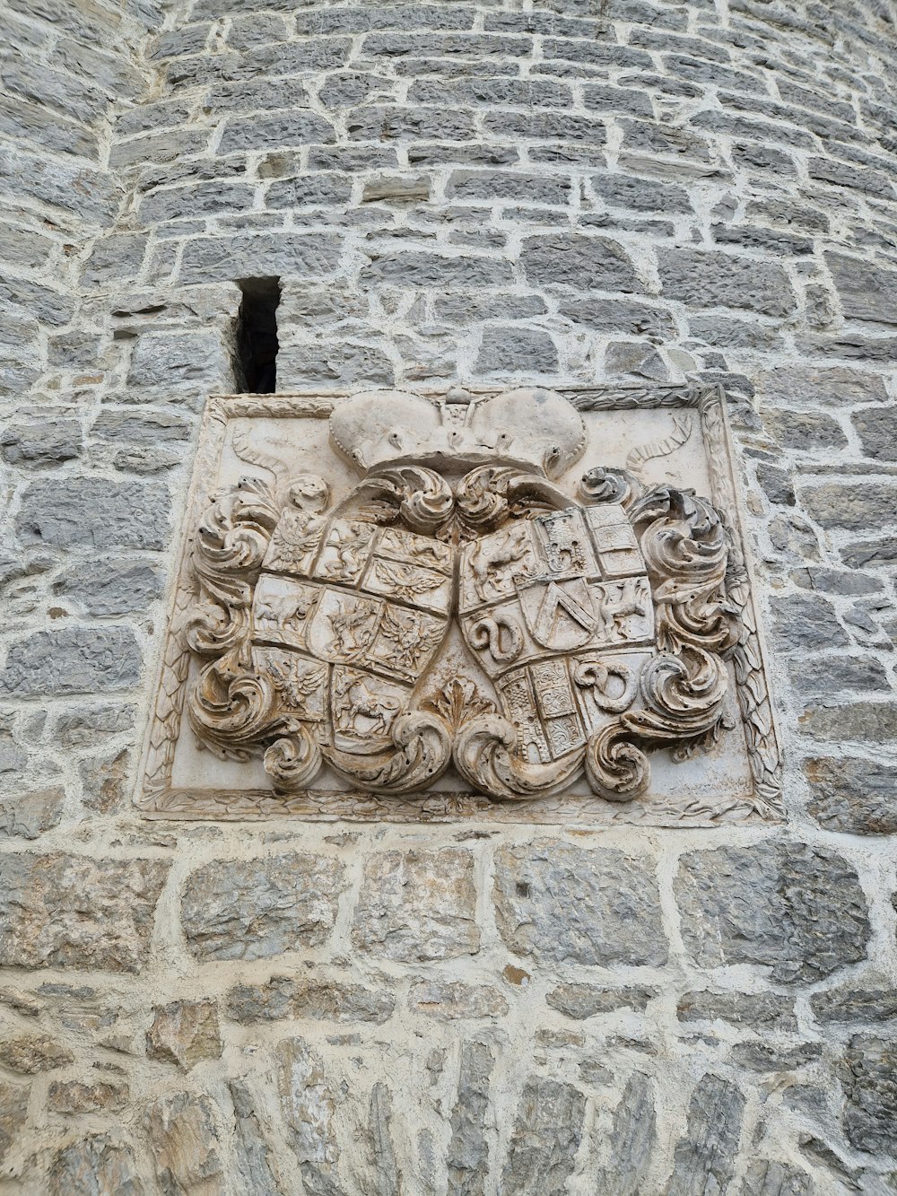 a stone building with a coat of arms on it
