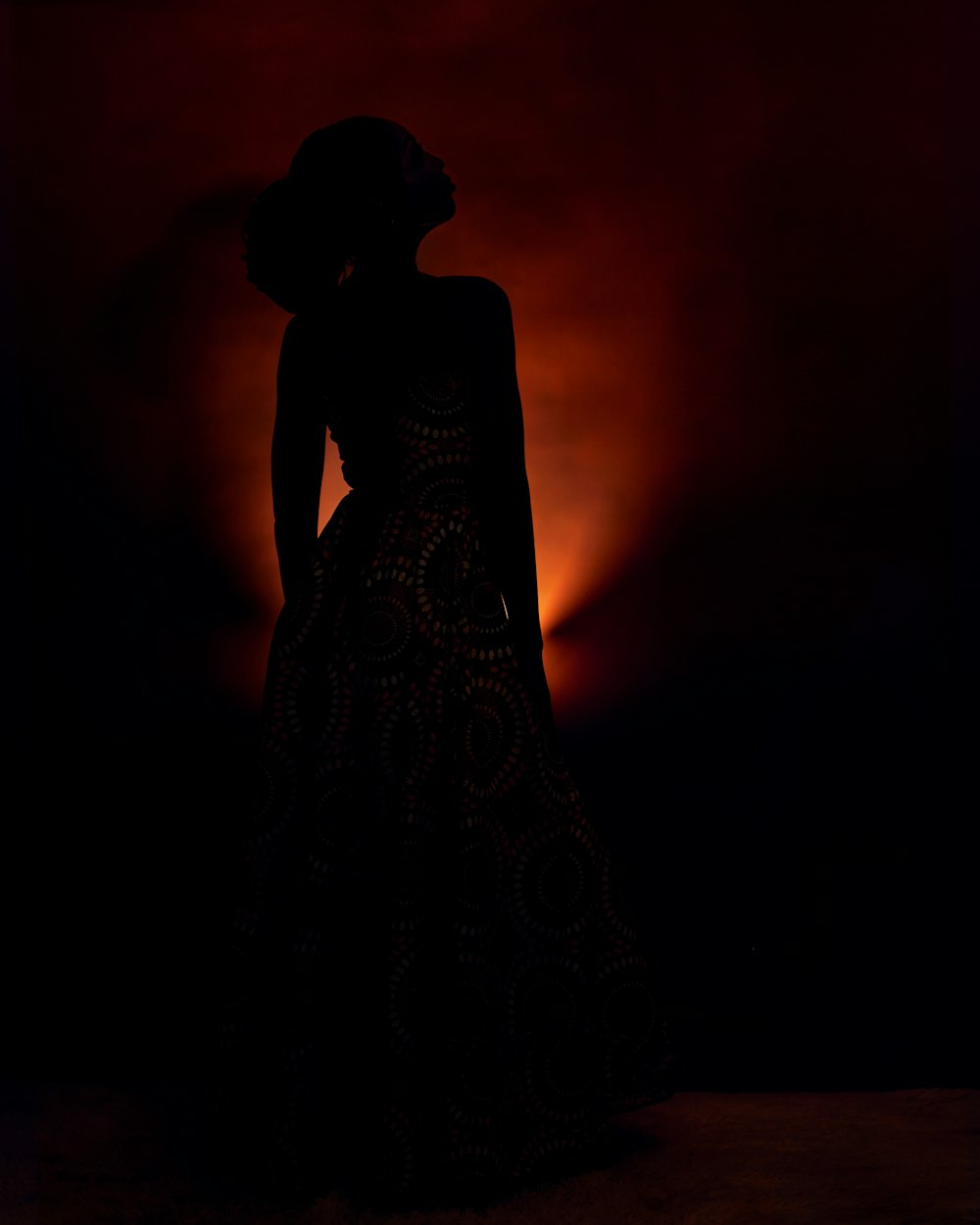a silhouette of a woman in a long dress