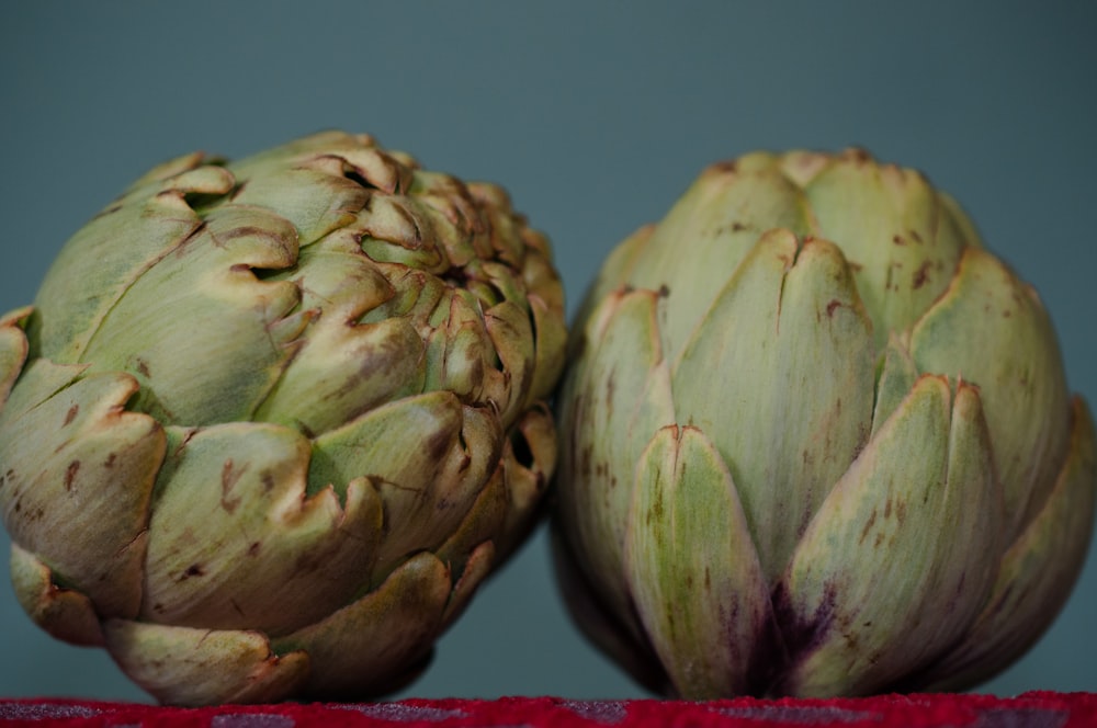 a couple of artichokes sitting on top of a table