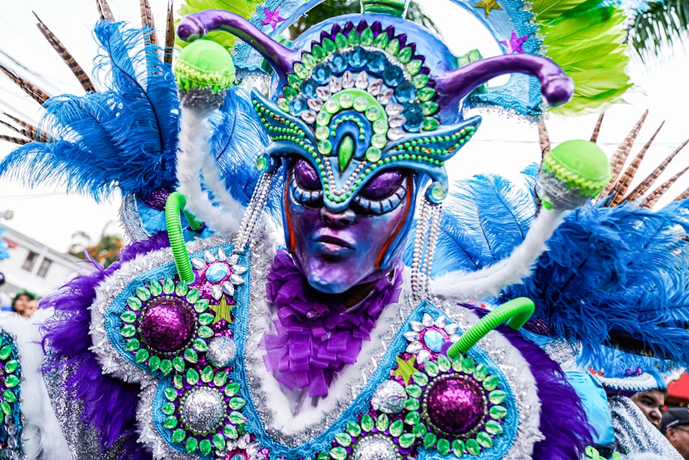 a man in a colorful costume with feathers on his head