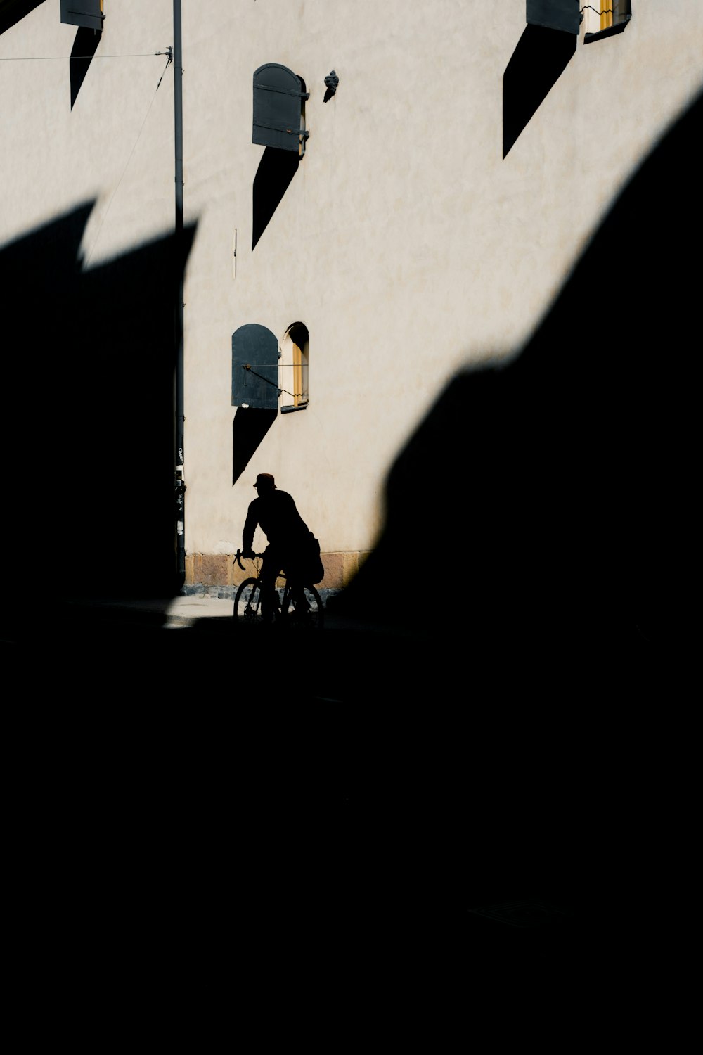 a man riding a bike down a street next to a tall building