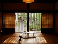 Peaceful interior living room with tatami mats and shoji screens letting in soft light.