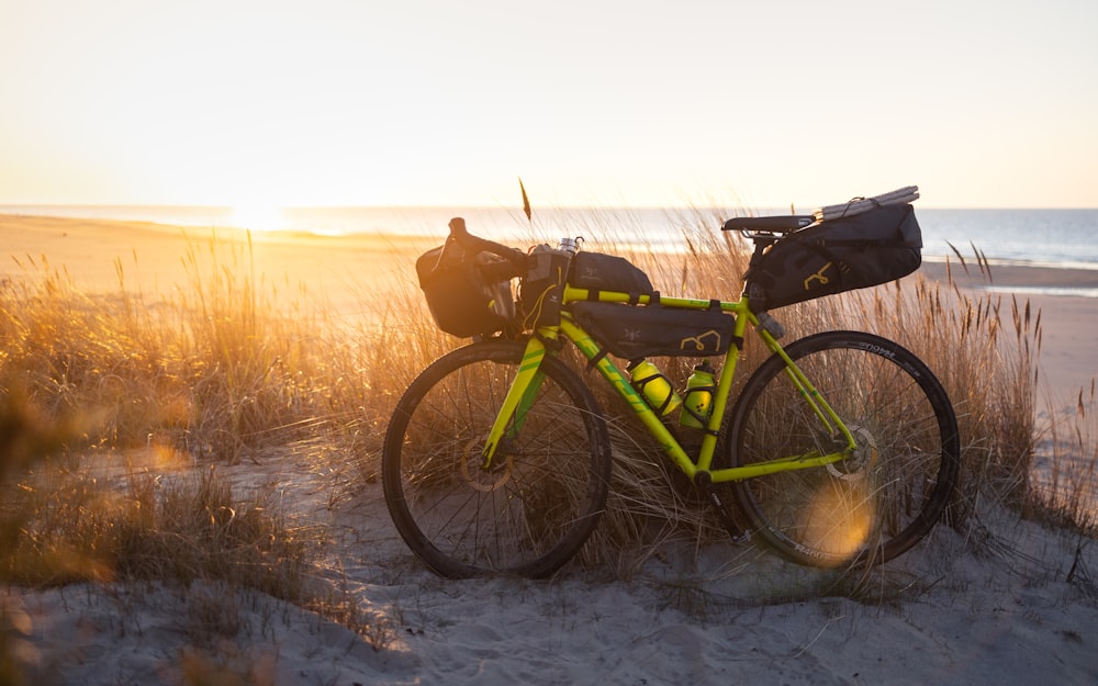 a yellow bicycle parked on a sandy beach