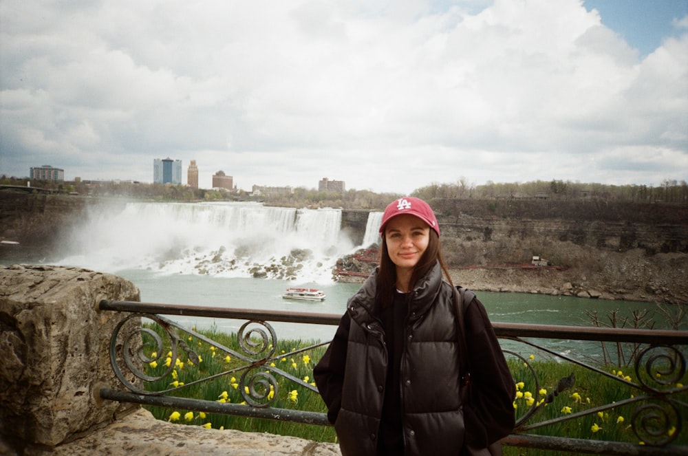 a woman standing in front of a waterfall