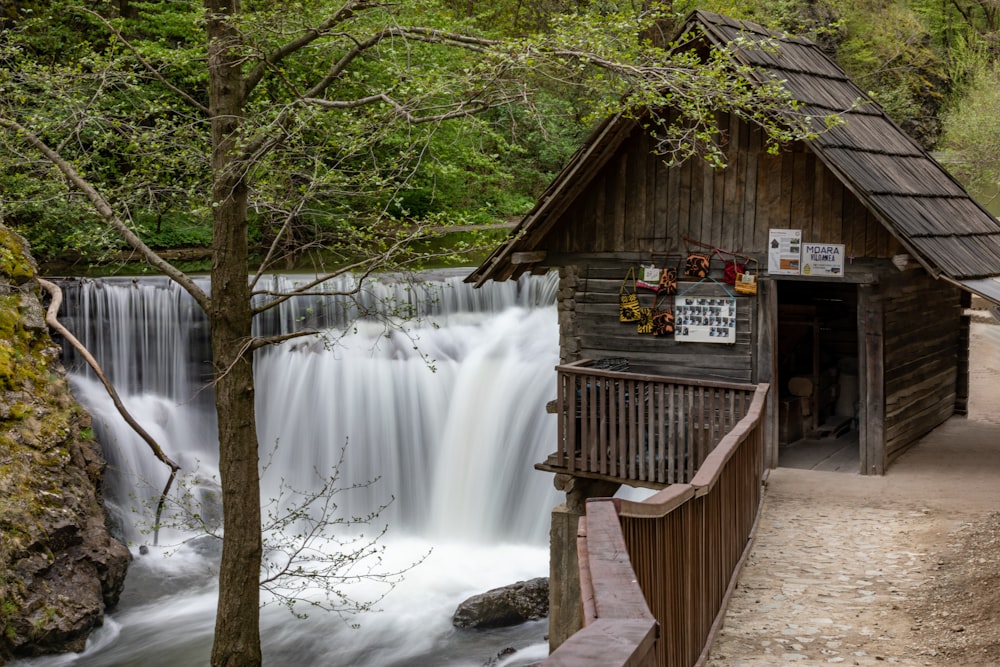 a wooden building with a waterfall in the background