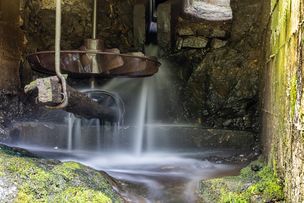 a small stream of water running through a stone tunnel