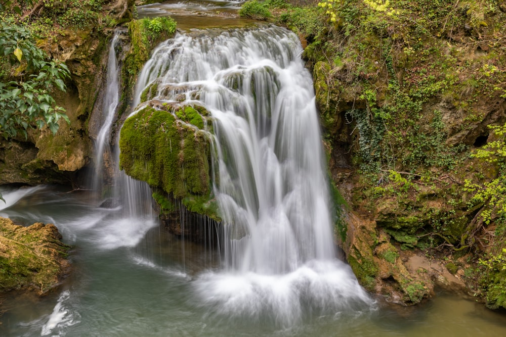 a small waterfall in the middle of a forest