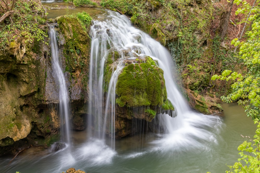 a small waterfall in the middle of a forest