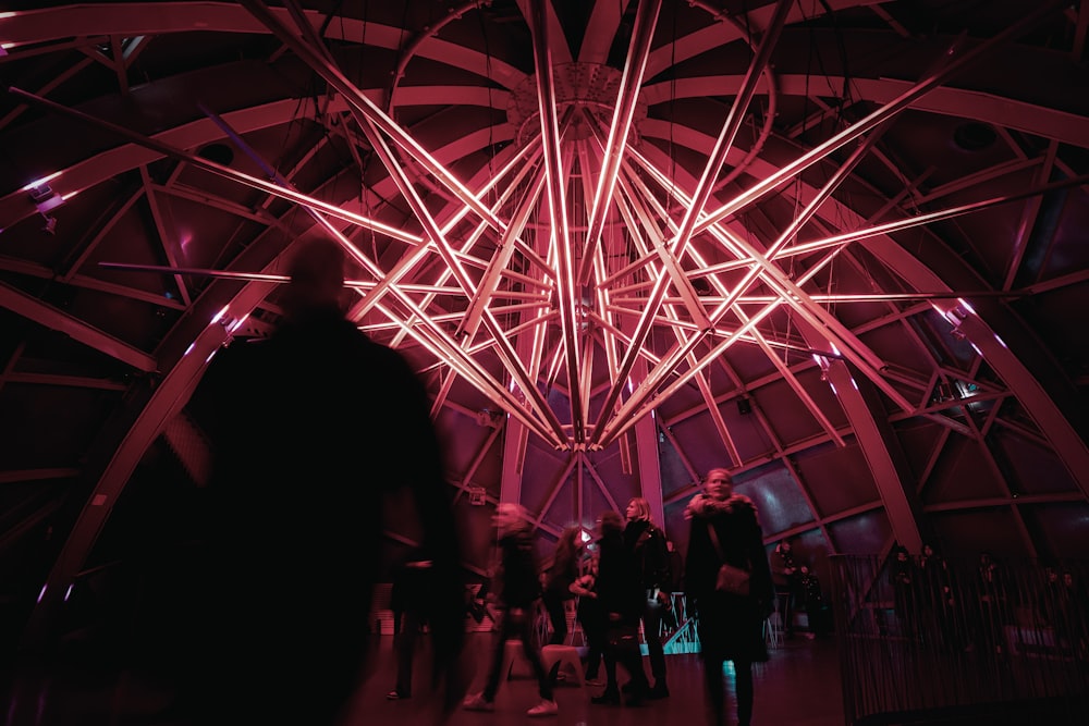 a group of people standing in a room with red lights