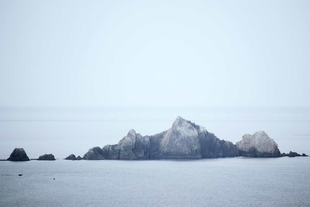 a large rock out in the middle of a body of water