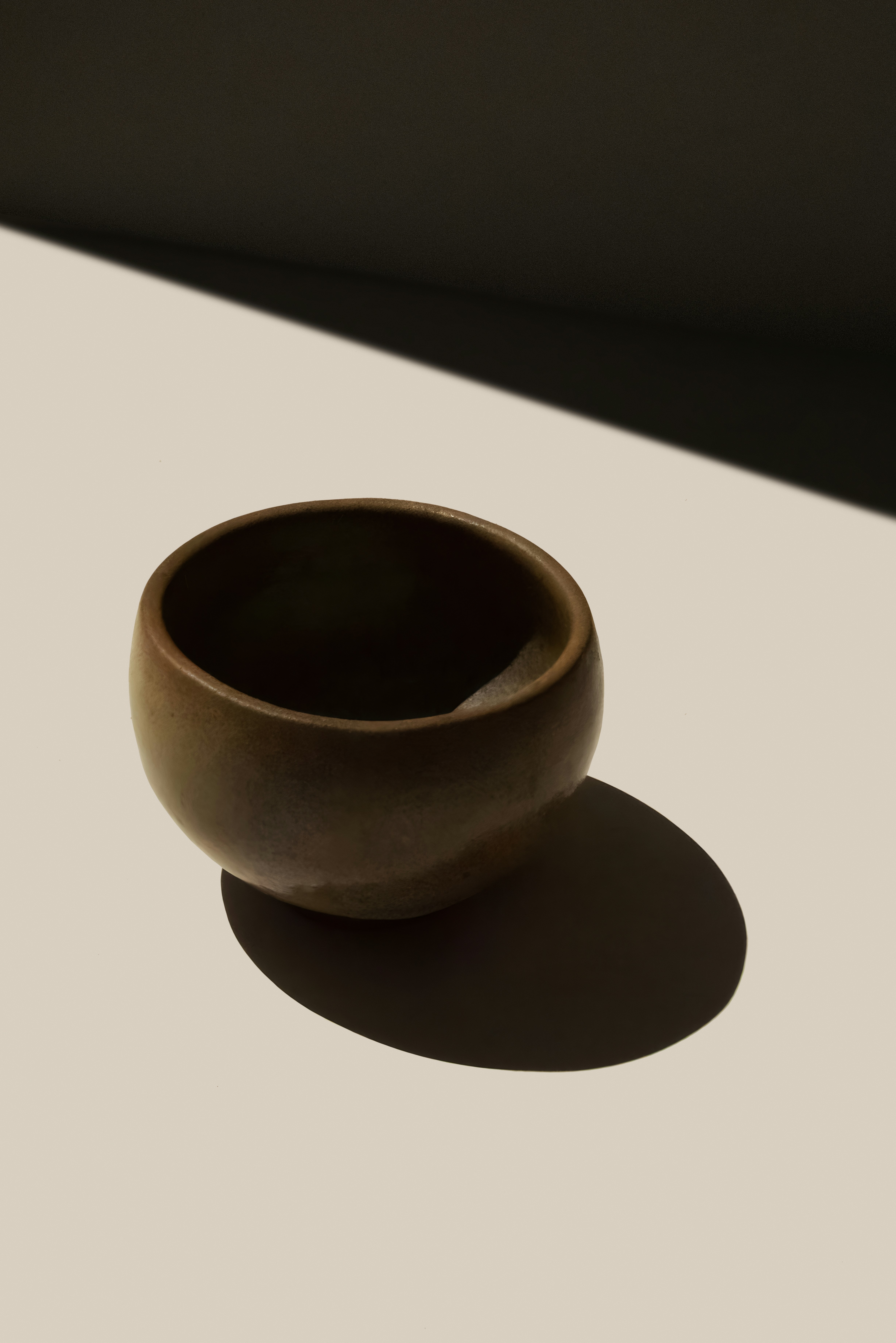a brown bowl sitting on top of a white table