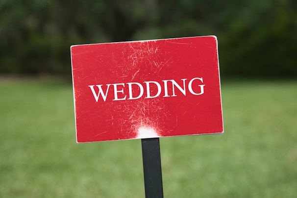 a red wedding sign sitting on top of a black pole