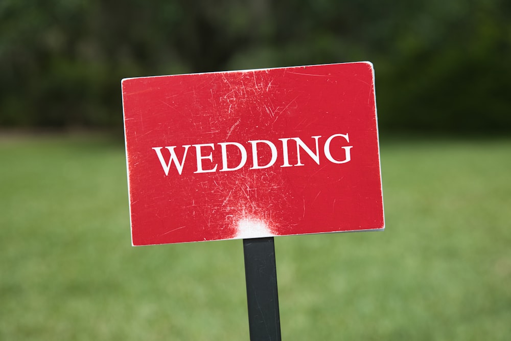 a red wedding sign sitting on top of a black pole