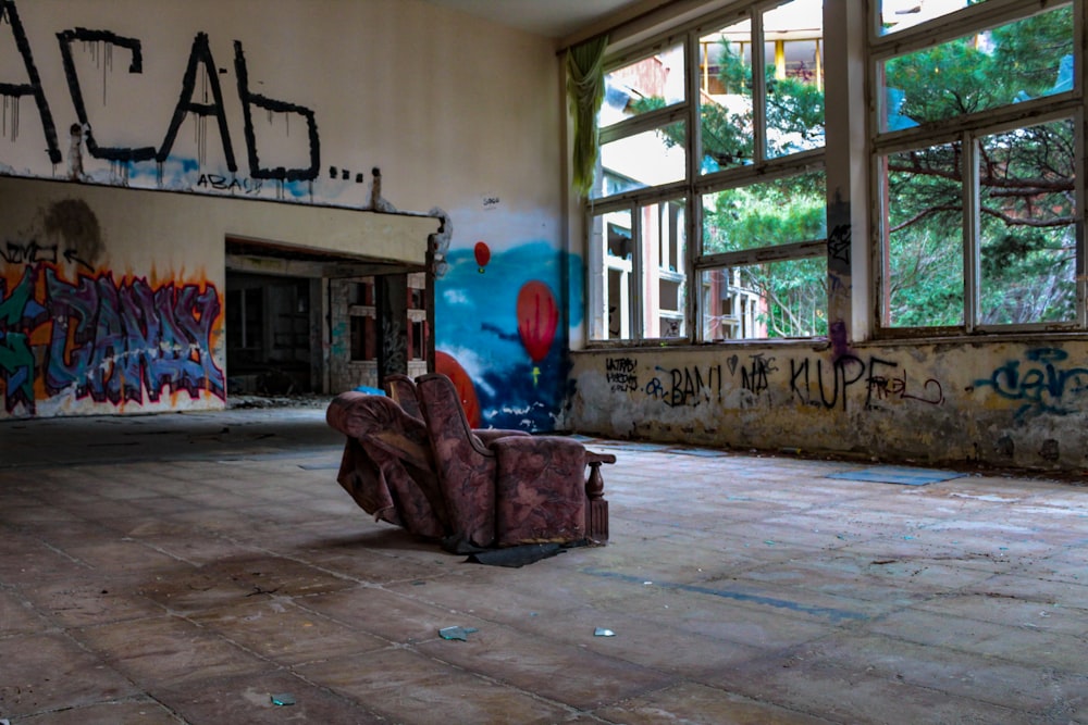 a chair sitting in an empty room with graffiti on the walls