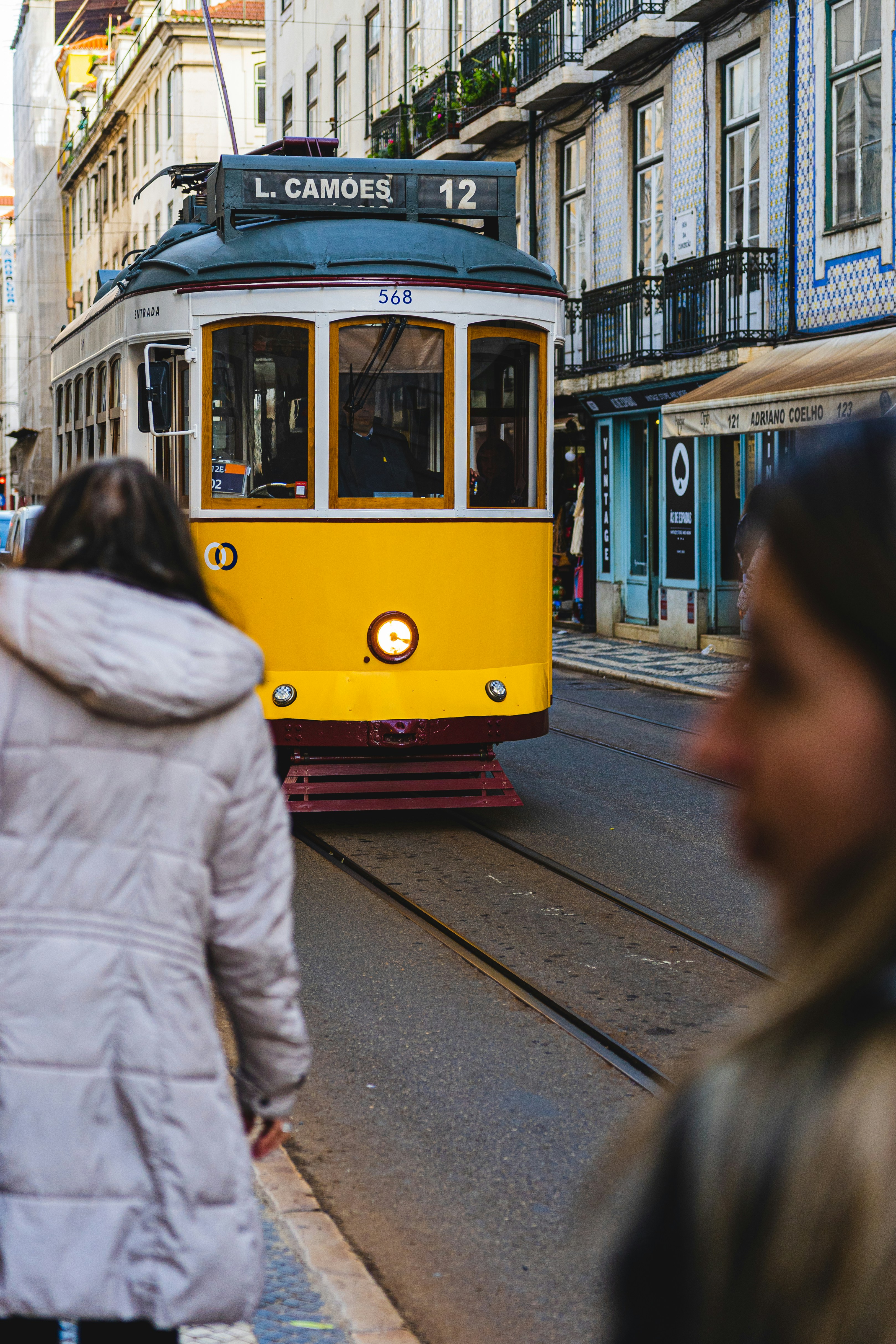 un tramway jaune circulant dans une rue à côté de grands immeubles