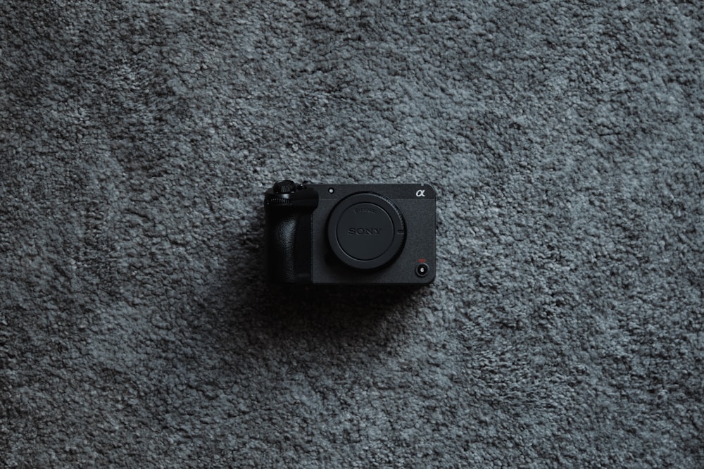 a black camera sitting on top of a gray carpet