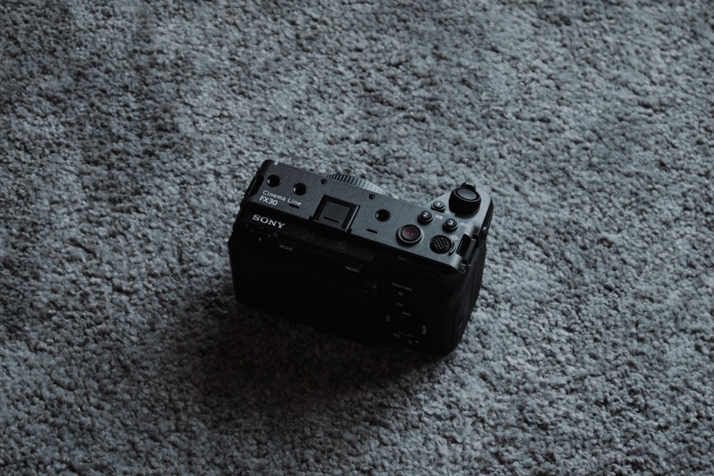a black camera sitting on top of a carpet