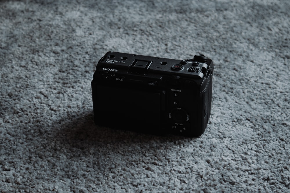 a black camera sitting on a gray carpet