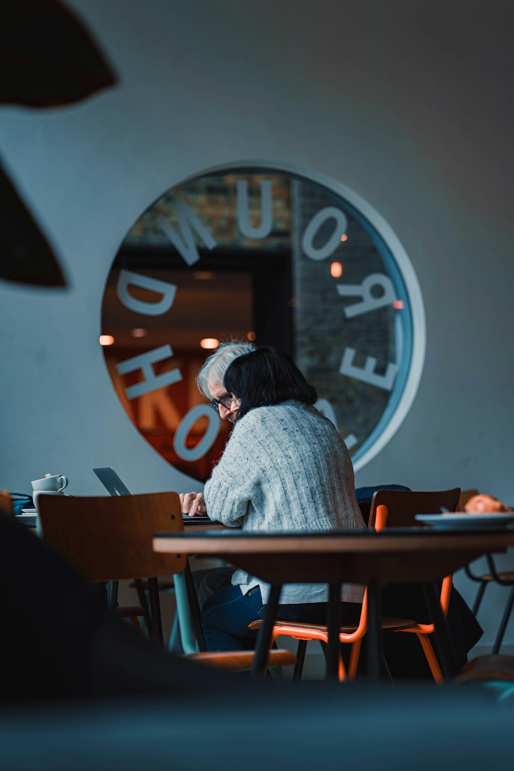 a woman sitting at a table with a laptop