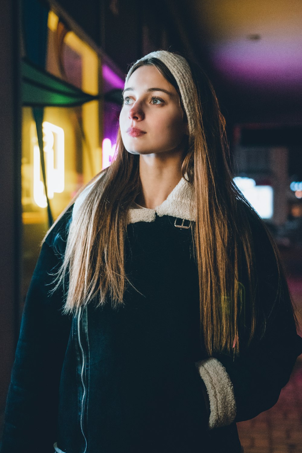 a woman with long hair standing in a dark room