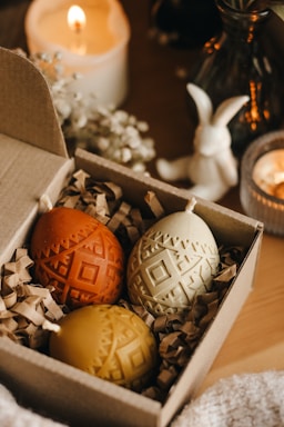 An elegant gift box containing three luxury candles arranged neatly with a Ramadan themed decoration.