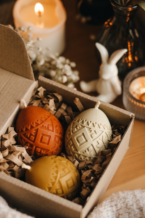 An elegant gift box containing three luxury candles arranged neatly with a Ramadan themed decoration.