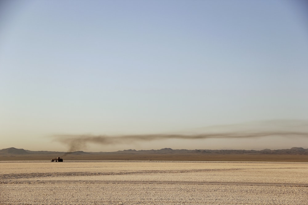 a couple of vehicles driving through a desert