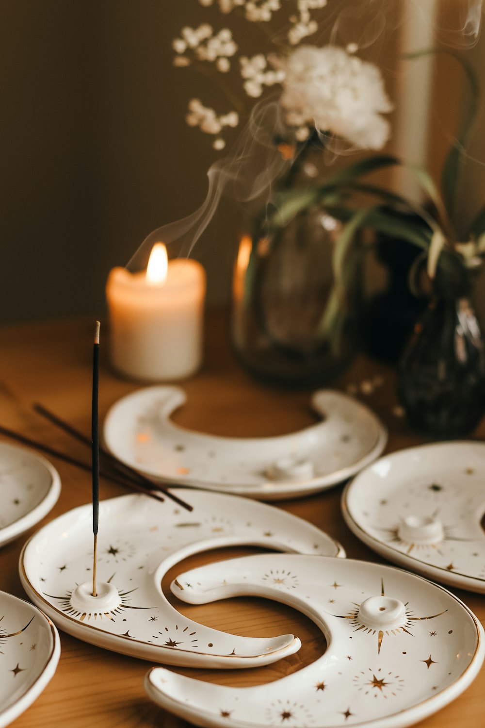 a wooden table topped with white plates and a candle