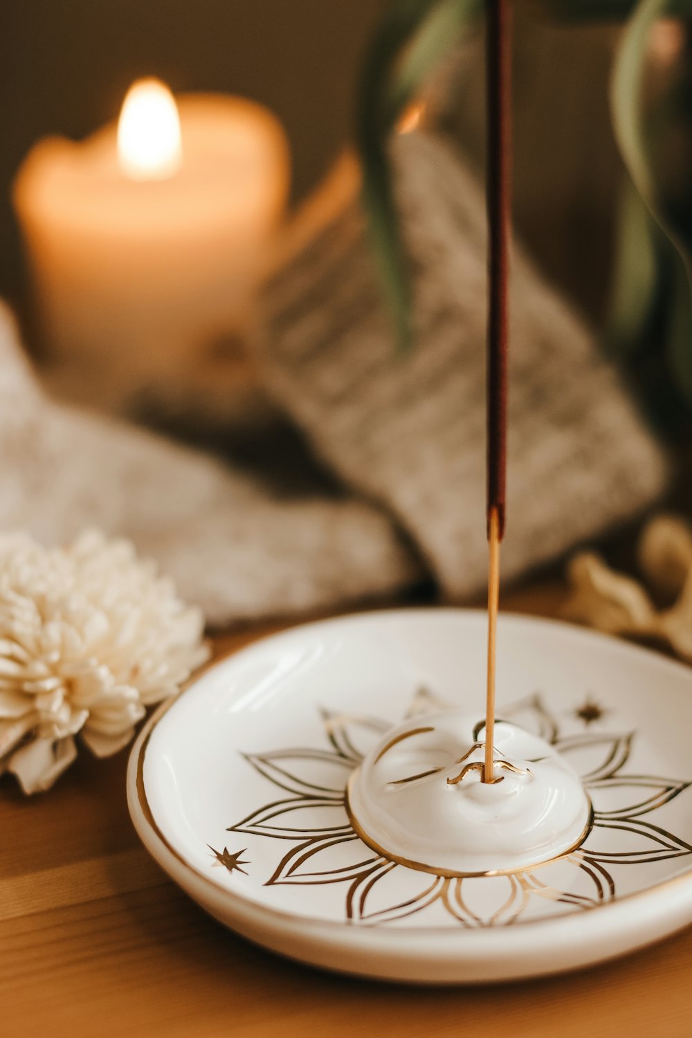 a white plate with a candle on top of it