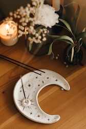 A rustic wooden table with natural crystals, dried flowers, and a lit candle creating a ritual atmosphere.