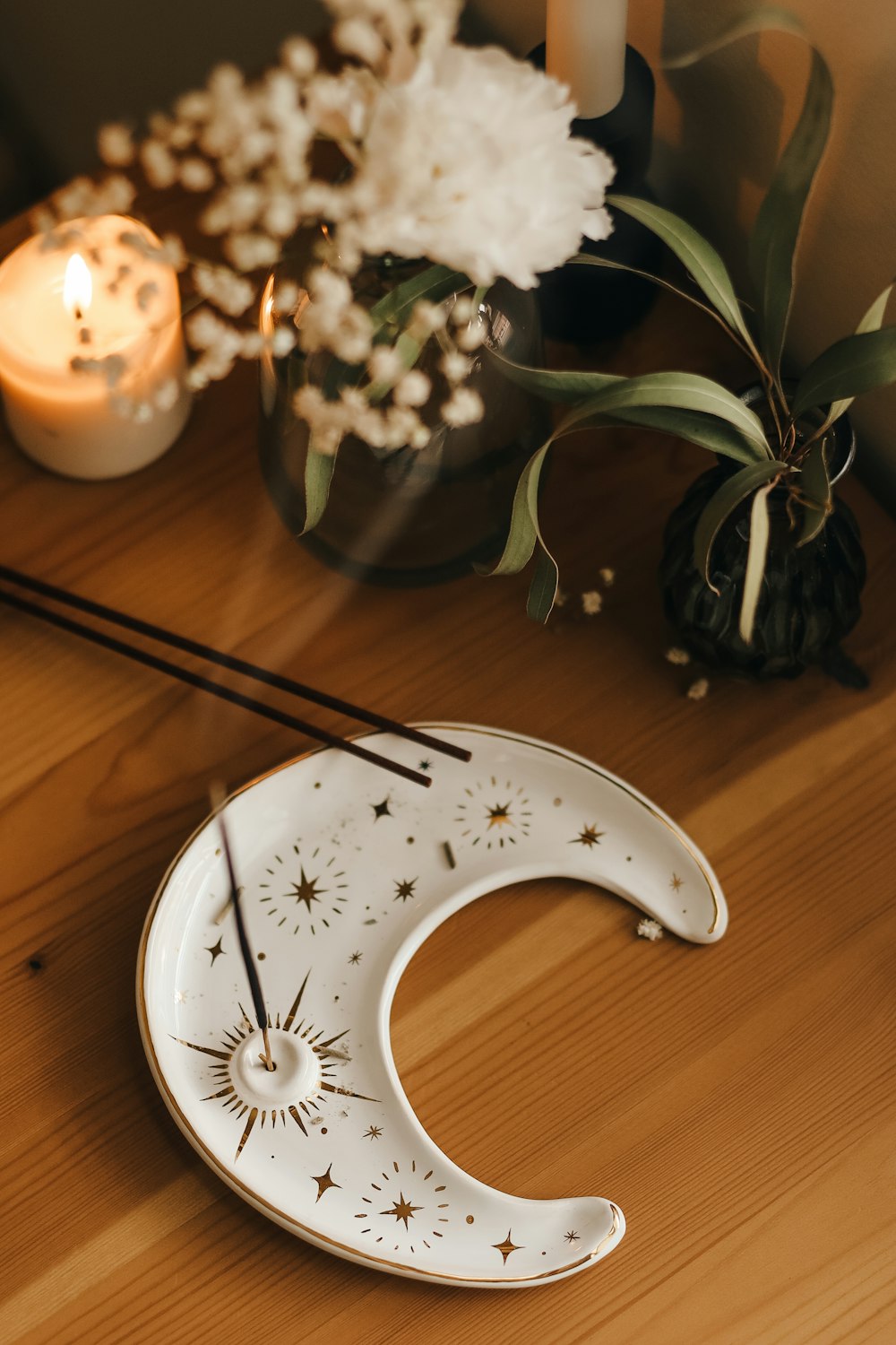 a wooden table topped with a white moon shaped plate