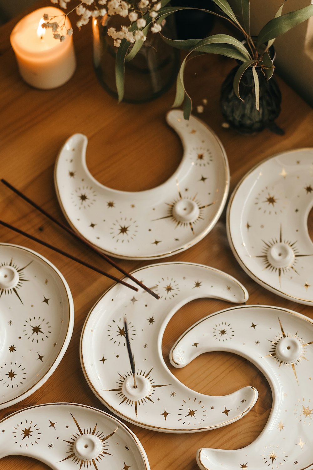 a wooden table topped with white plates and candles