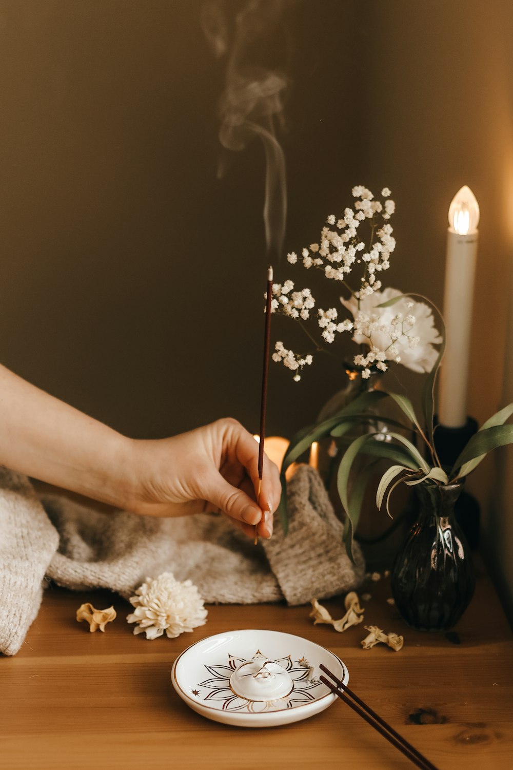 a person lighting a candle on a table