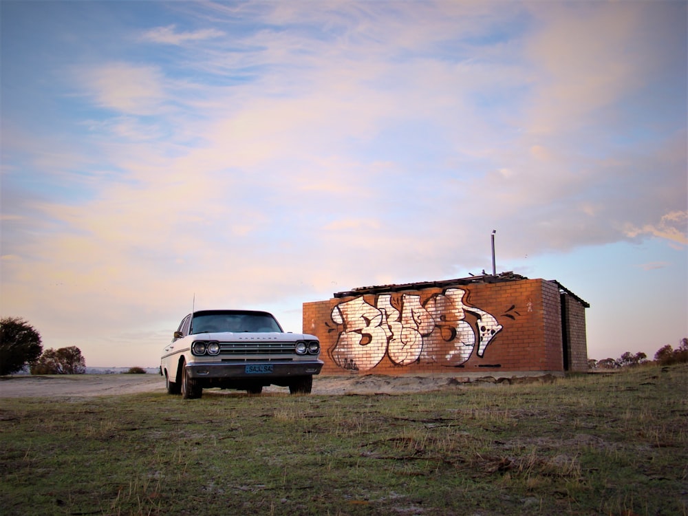 a truck parked in front of a building with graffiti on it