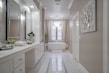 A stylish vanity with a large mirror and elegant lighting in a cozy bathroom.