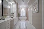 A stylish vanity with a large mirror and elegant lighting in a cozy bathroom.