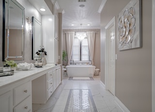 a bathroom with a tub, sink, and mirror