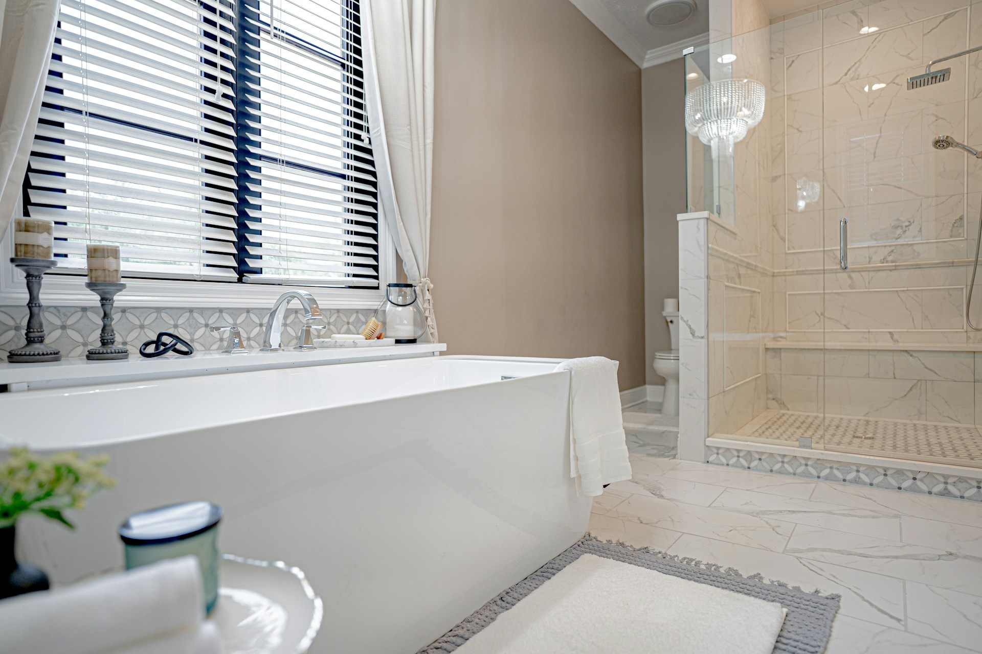A stylish bathtub surrounded by elegant tiles and ambient lighting.