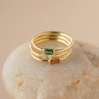a stack of three rings sitting on top of a rock