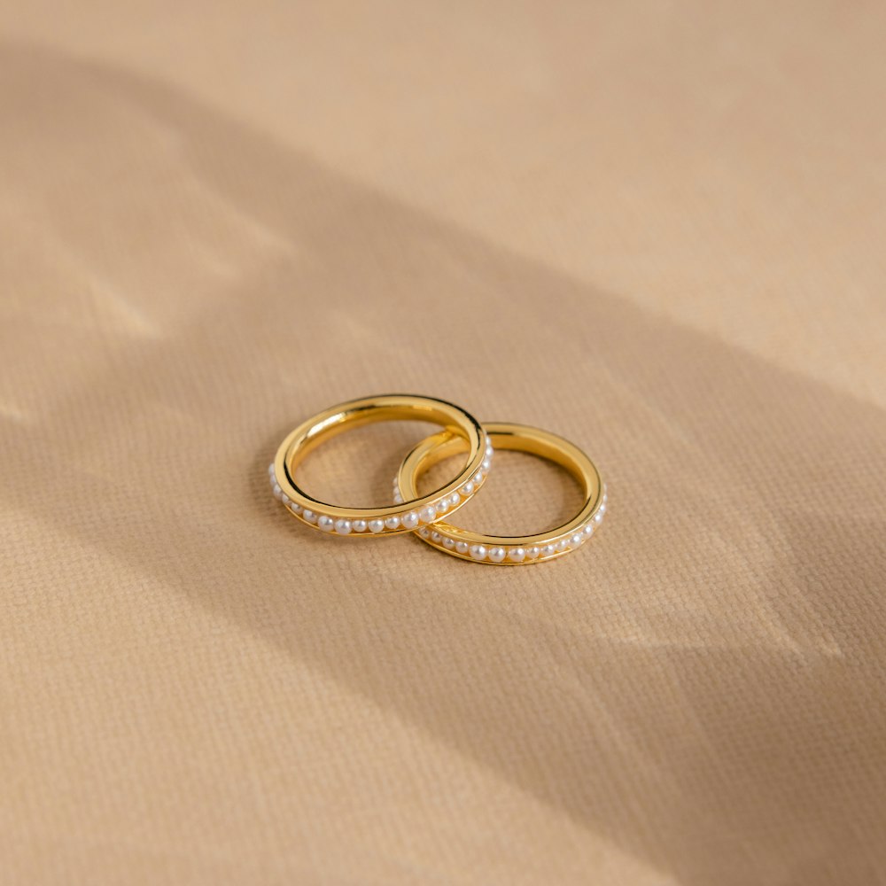 two wedding rings sitting on top of a table
