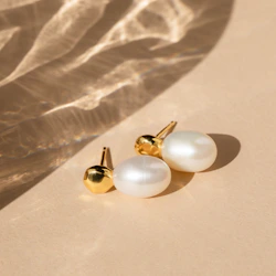 Close-up of elegant silver earrings displayed on a soft beige fabric background.
