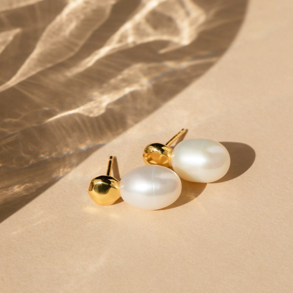 a pair of pearl earrings sitting on top of a table