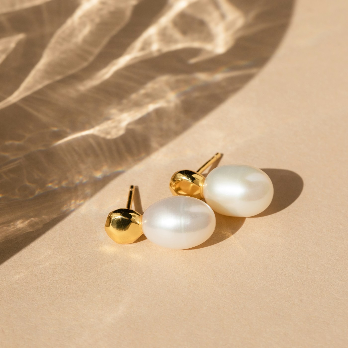 Pair of Sterling Pearl Drops on warm ivory sand - freshwater drop pearls on hand-cast 18k caps