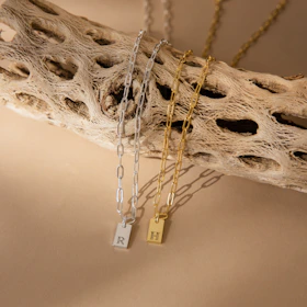 An elegant display of several memory necklaces on a minimalist wooden stand, each piece telling its own story.