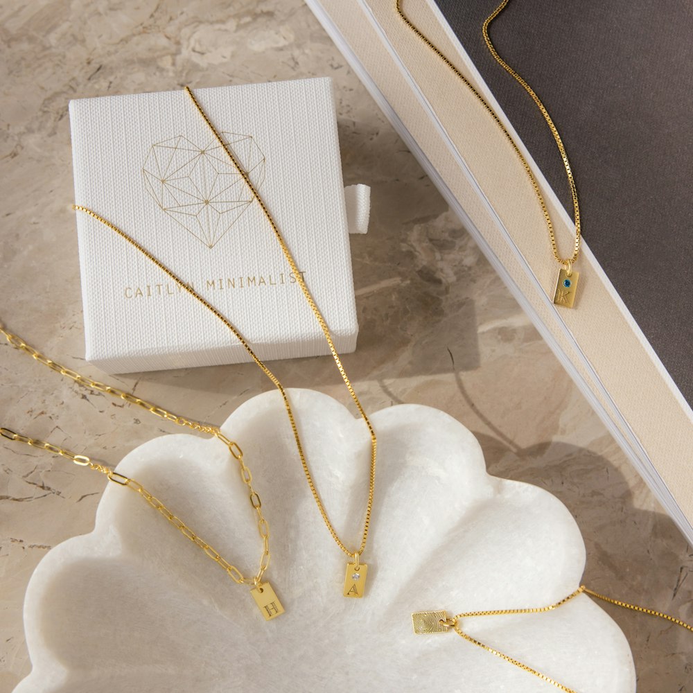 a set of three necklaces sitting next to a box