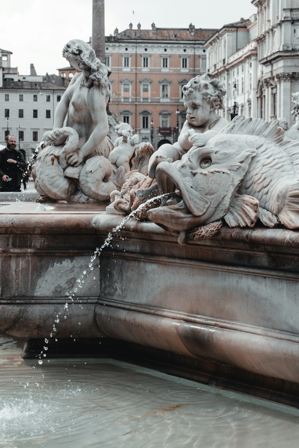 a fountain with statues of animals and people around it